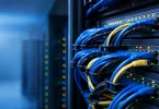 Sunucu odasinda patch panele baglanmis renkli ethernet kablolari ve yesil isik gostergeleri, DNS ag altyapisi metaforu